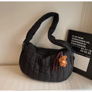 Chic black quilted shoulder bag with fluffy bear charm and stylish drawstring detail