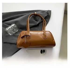 Brown faux leather baguette bag size comparison with smartphone and heart charm