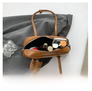 Top view of brown leather bag interior showing capacity for phone and cosmetics