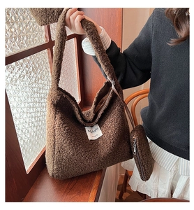 Detail of soft brown plush tote bag texture with logo label and small matching pouch