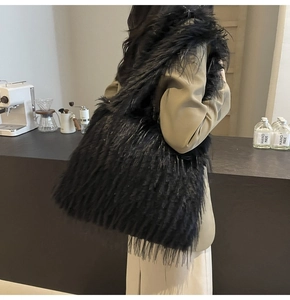Detail shot of a large black fuzzy faux fur tote bag with a soft plush texture for winter