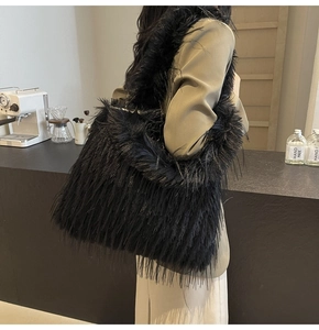 Detail of a plush black faux fur shoulder tote bag for women in a stylish urban setting