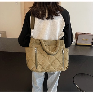 Detail of olive green quilted nylon shoulder bag showing crossbody strap and texture