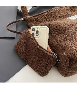 Detail of plush tote bag side pocket showing storage capacity for a smartphone