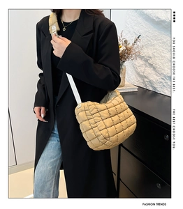 Quilted beige puffer bag with wide strap styled with a casual blazer and denim outfit