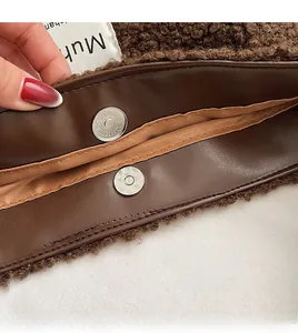 Close-up of brown plush teddy fabric with premium leather trim and magnetic metal clasp