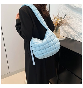 Detailed view of light blue puffer tote bag with quilted pattern and puffy texture