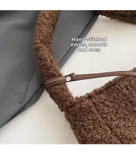 Detail showing the brown plush tote bag with fine stitching and leather strap buckles