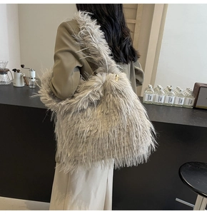 Detail of grey fluffy faux fur shoulder bag worn by model over a dark blazer