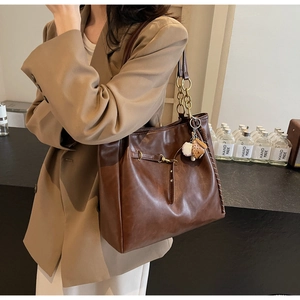 Brown PU leather tote bag featuring a gold chain strap and a unique baseball charm