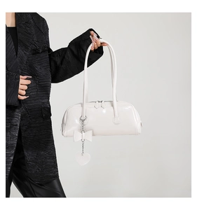 Chic white PU leather handbag with heart pendant shown on model in a studio setting