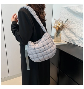 Detail view of the quilted puff shoulder bag in light purple with thick strap and soft texture