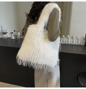 Detail of soft white faux fur tote bag showing plush texture and wide shoulder strap