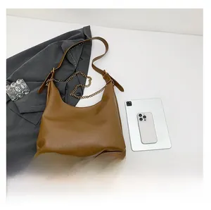 Detailed top view of a brown PU leather crescent shoulder bag with golden chain accent