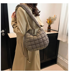 Detail view of grey quilted down fabric shoulder bag with padded wide strap for comfort