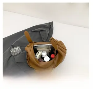 Interior view showing large capacity of the pleated dark camel PU leather shoulder bag