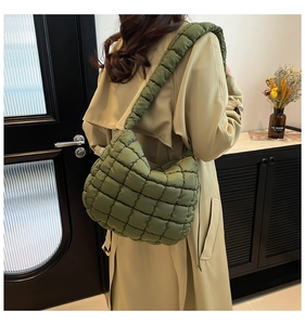 Army green quilted puffer hobo bag with wide shoulder strap shown on a model