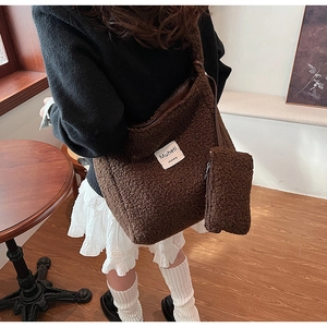 Detail of plush brown shearling tote bag with matching mini pouch in cozy indoor setting