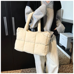 Detail of a quilted ivory tote bag showing the soft nylon texture and large grid pattern