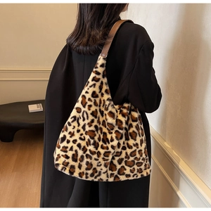 Dettaglio della borsa tote in peluche leopardata con tracolla in pelle marrone indossata