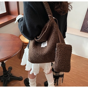 Detail of dark brown faux shearling tote bag with matching pouch and woven brand label