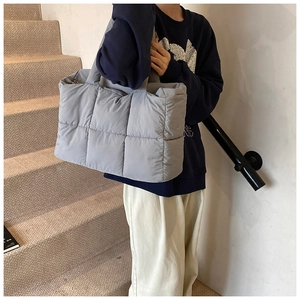 Close-up of quilted light gray tote bag with large square stitching and soft texture