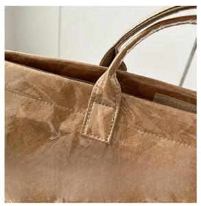 Dettaglio della borsa tote in carta Tyvek marrone con strato in PVC e cuciture a vista