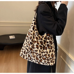 Dettaglio laterale di una borsa tote grande in pelliccia sintetica maculata su modella