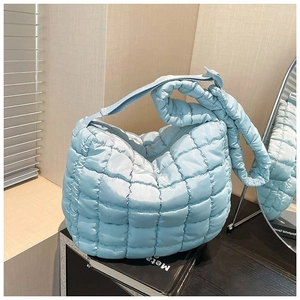 Light blue quilted puff shoulder bag with soft nylon texture and wide padded strap