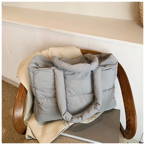 Minimalist light gray quilted puffer tote bag with parallel stitching and top zipper closure