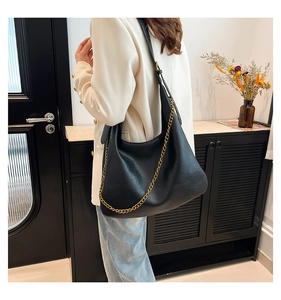 Detail view of black PU leather hobo bag with gold chain and adjustable shoulder strap