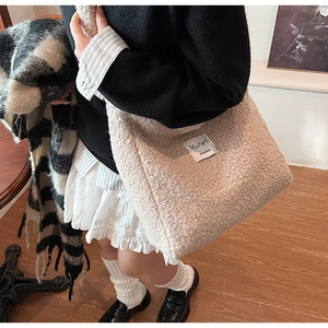 Close-up of fluffy fleece tote bag in beige with branded label for autumn winter fashion