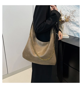 Detail view of stylish brown faux leather hobo shoulder bag with elegant gold chain strap