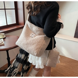 Close-up of fluffy off-white sherpa tote bag with magnetic clasp and matching small pouch