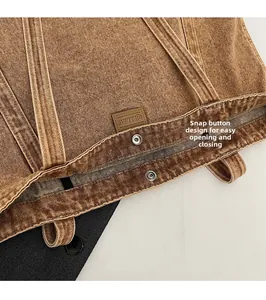 Detail of vintage brown canvas tote bag featuring metal snap closure and logo patch