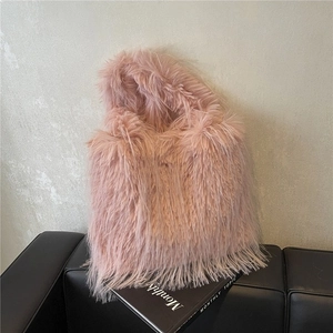 Pink faux fur tote bag with plush texture on a black leather sofa for fall fashion