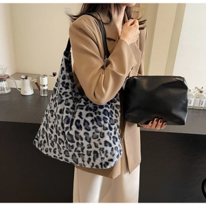 Dettaglio di borsa tote in ecopelliccia leopardata e pochette nera in un caffè