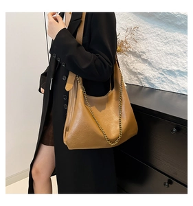 Detail of caramel lychee grain hobo bag with gold chain and wide shoulder strap