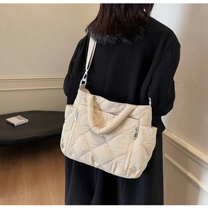 Detail of beige quilted shoulder bag featuring durable nylon fabric and diamond texture