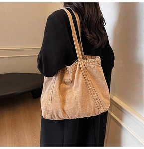 Close-up of vintage washed canvas tote bag featuring premium leather label and wide straps