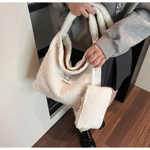 Close-up of white plush tote bag with magnetic closure and matching zipper pouch