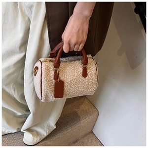 Détail du sac Boston en peluche avec poignées en PU marron et finitions dorées chic