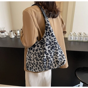 Borsa tote in peluche leopardata vista dal retro su una modella in un ambiente minimal