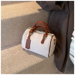 Vue détaillée des textures de laine d'agneau blanche et des bordures en cuir marron du sac