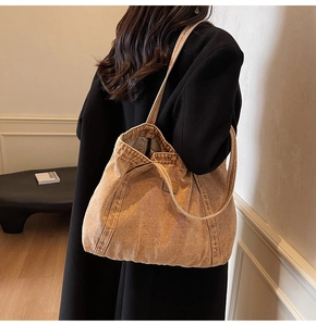 Detailed view of the large vintage brown canvas tote bag with a leather logo patch