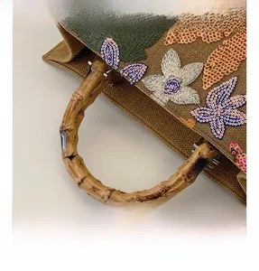 Detailed view of natural bamboo handles and exquisite floral sequin embroidery on linen tote
