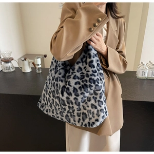 Dettaglio della borsa tote in peluche leopardata blu indossata con un blazer invernale