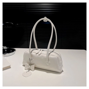 Stylish white PU leather handbag with heart charm and bow on a white surface