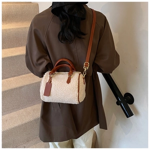 Détail du sac Boston en polaire avec bandoulière en cuir marron et boucles dorées