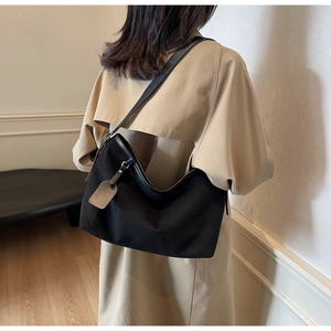 Mannequin portant un grand sac bandoulière en cuir PU noir au design demi-lune épuré